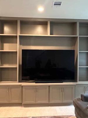 Custom built-in entertainment wall in painted taupe shaker by Sumpter Design and Build, head-on view